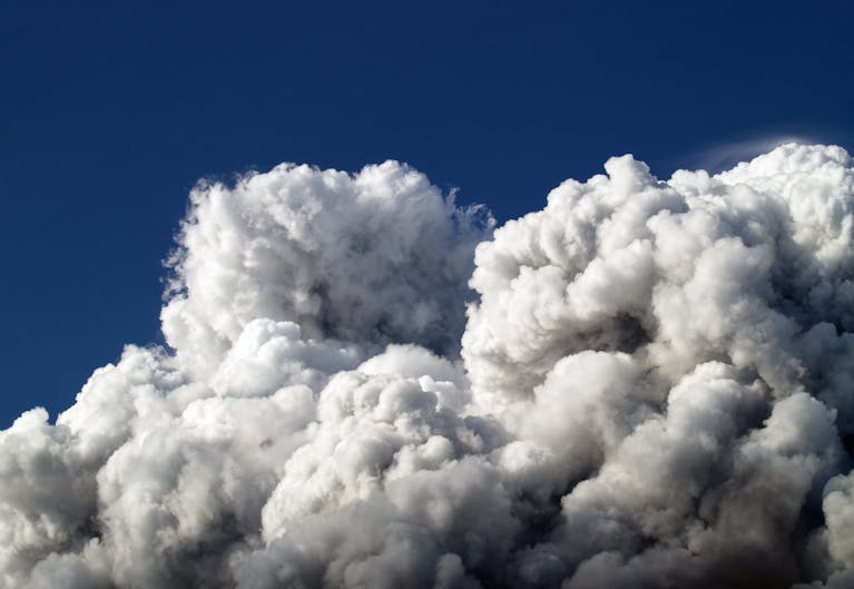 Majestic cumulus clouds forming a dramatic skyscape with a vibrant blue sky background.